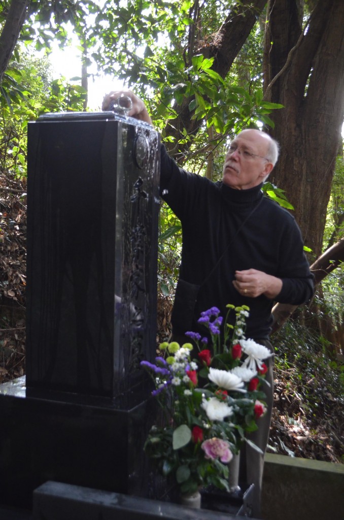 Darrell Bluhm Shihan pours sake on the memorial stone.